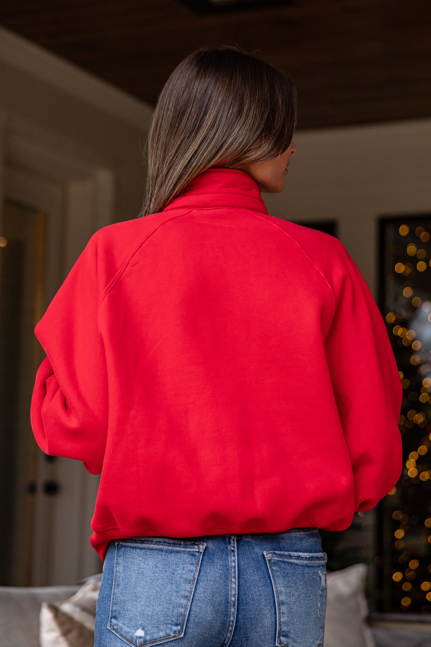 Person wearing a red jacket in an indoor setting with blurred background