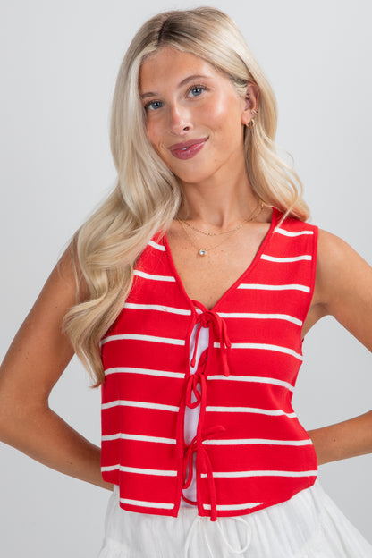 Woman wearing a red and white striped sleeveless top against a plain background