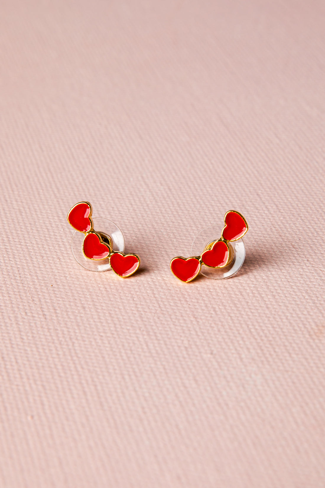 Heart-shaped earrings on a pink background