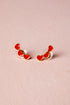 Heart-shaped earrings on a pink background