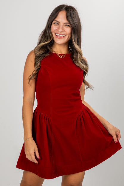 Woman wearing a red dress against a plain background