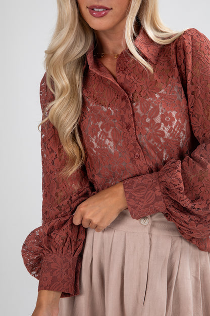 Woman wearing a red lace blouse with long sleeves on a white background