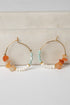 Pair of hoop earrings with colorful beads on a light background