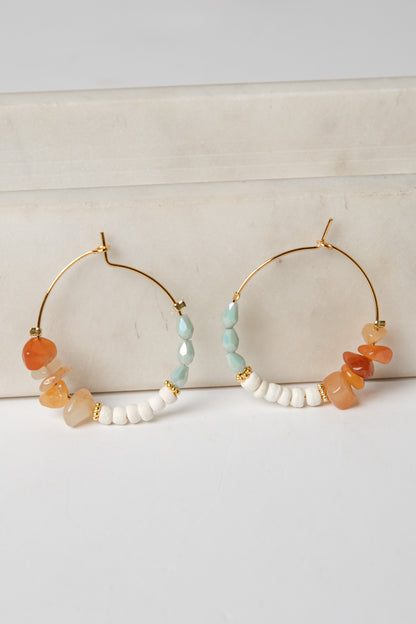 Pair of hoop earrings with colorful beads on a light background