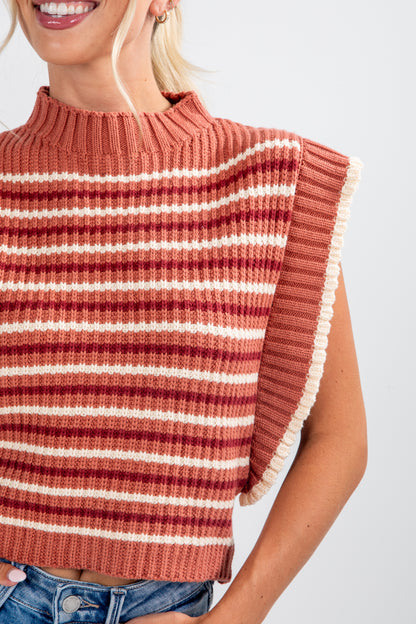 Woman wearing a striped sweater with fringes on a white background