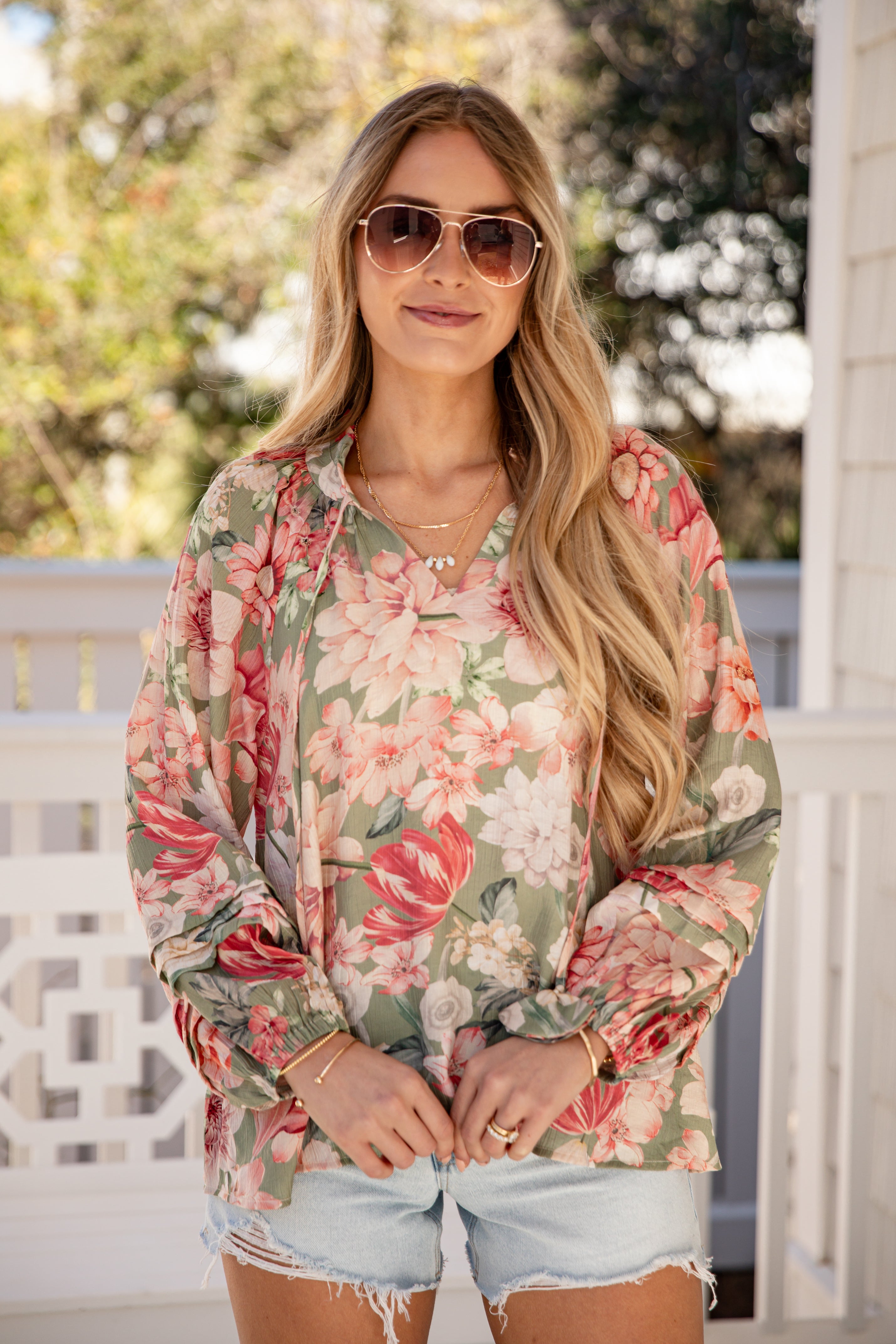 Woman wearing a floral shirt and sunglasses outdoors