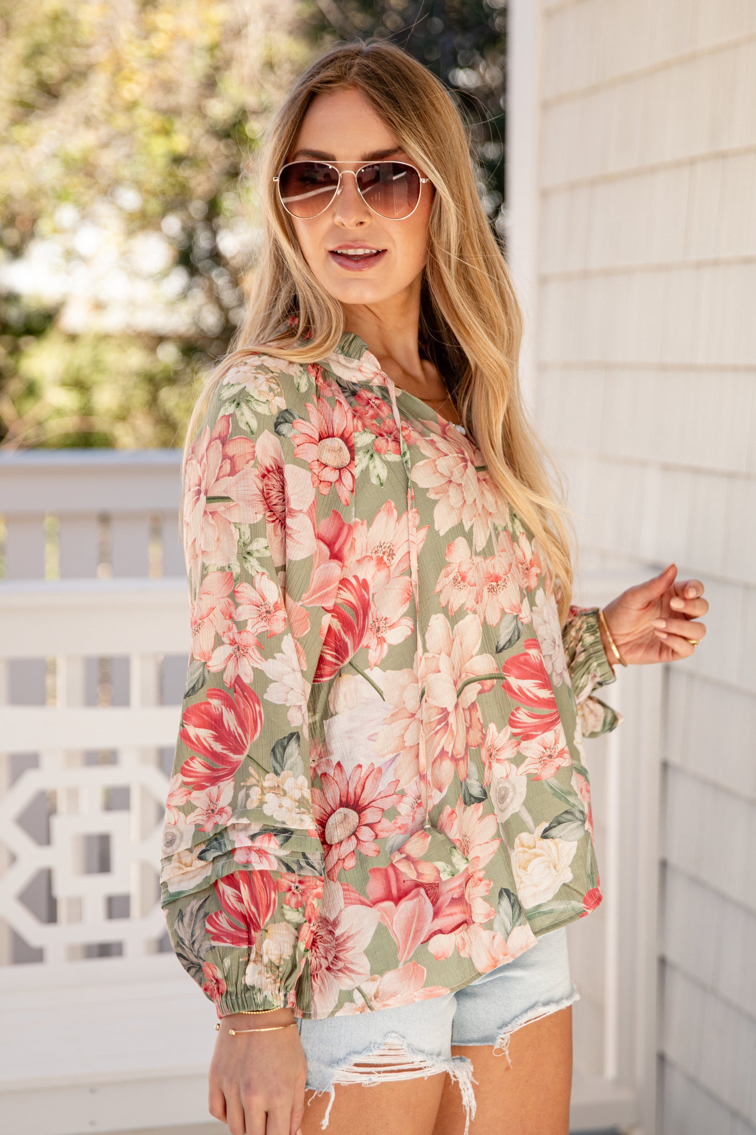 Woman wearing a floral shirt and sunglasses outdoors