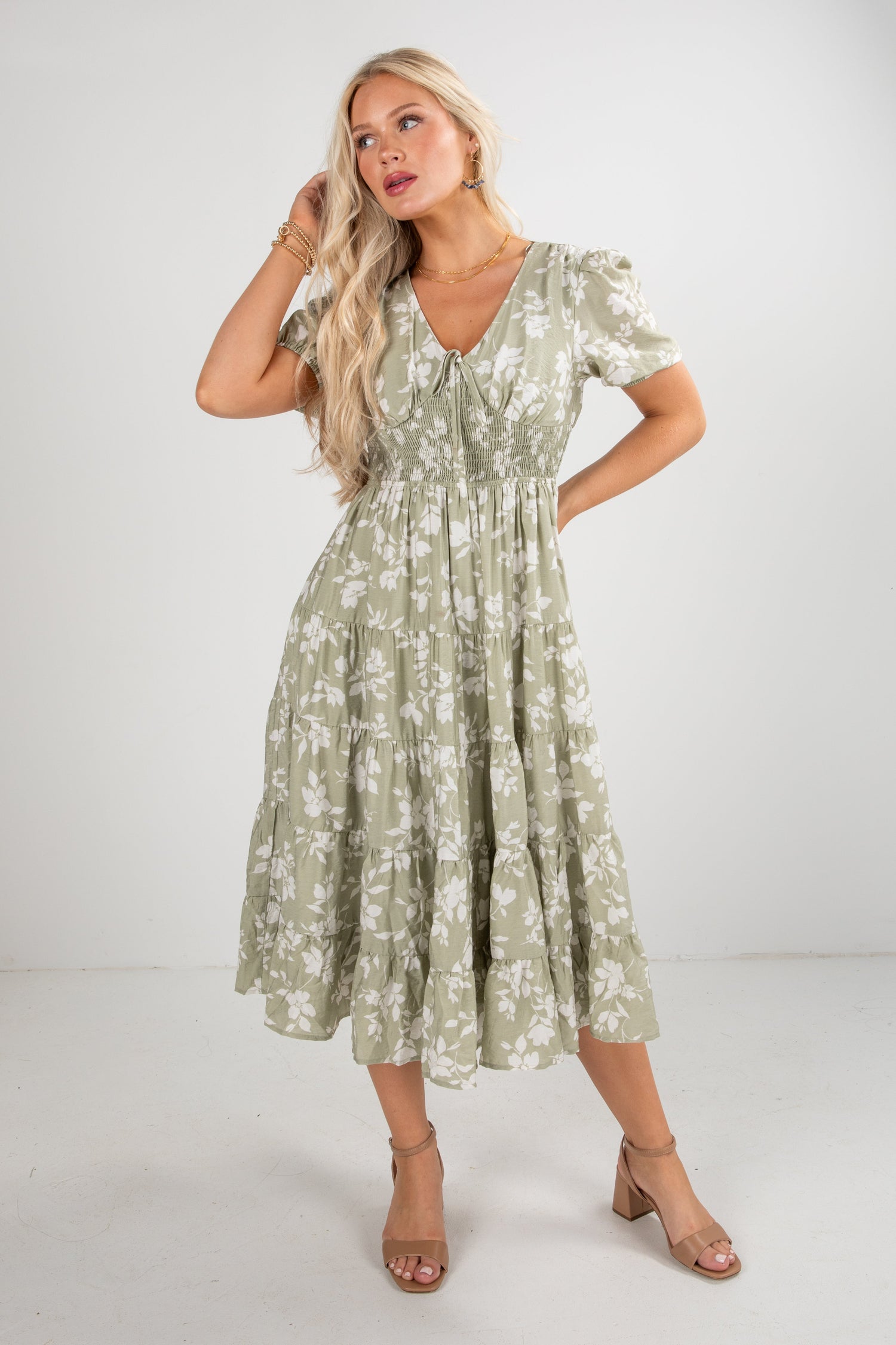 Woman wearing a green floral dress against a white background
