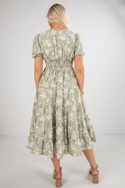 Woman wearing a green floral dress on a white background
