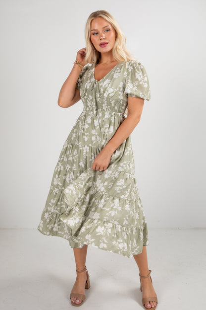Woman wearing a green floral dress on a white background