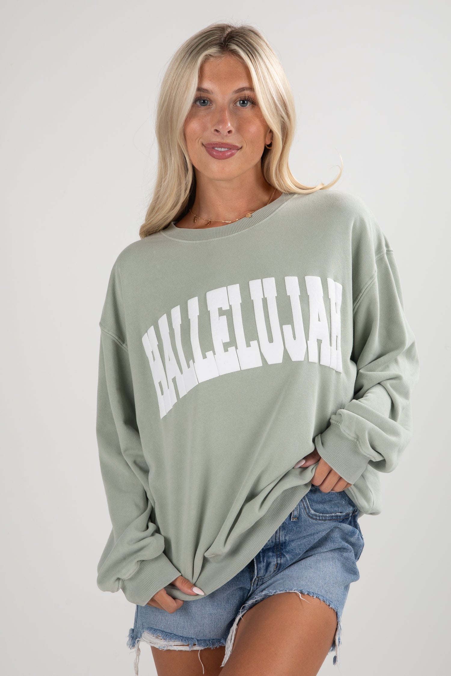 Woman wearing a green sweatshirt with &