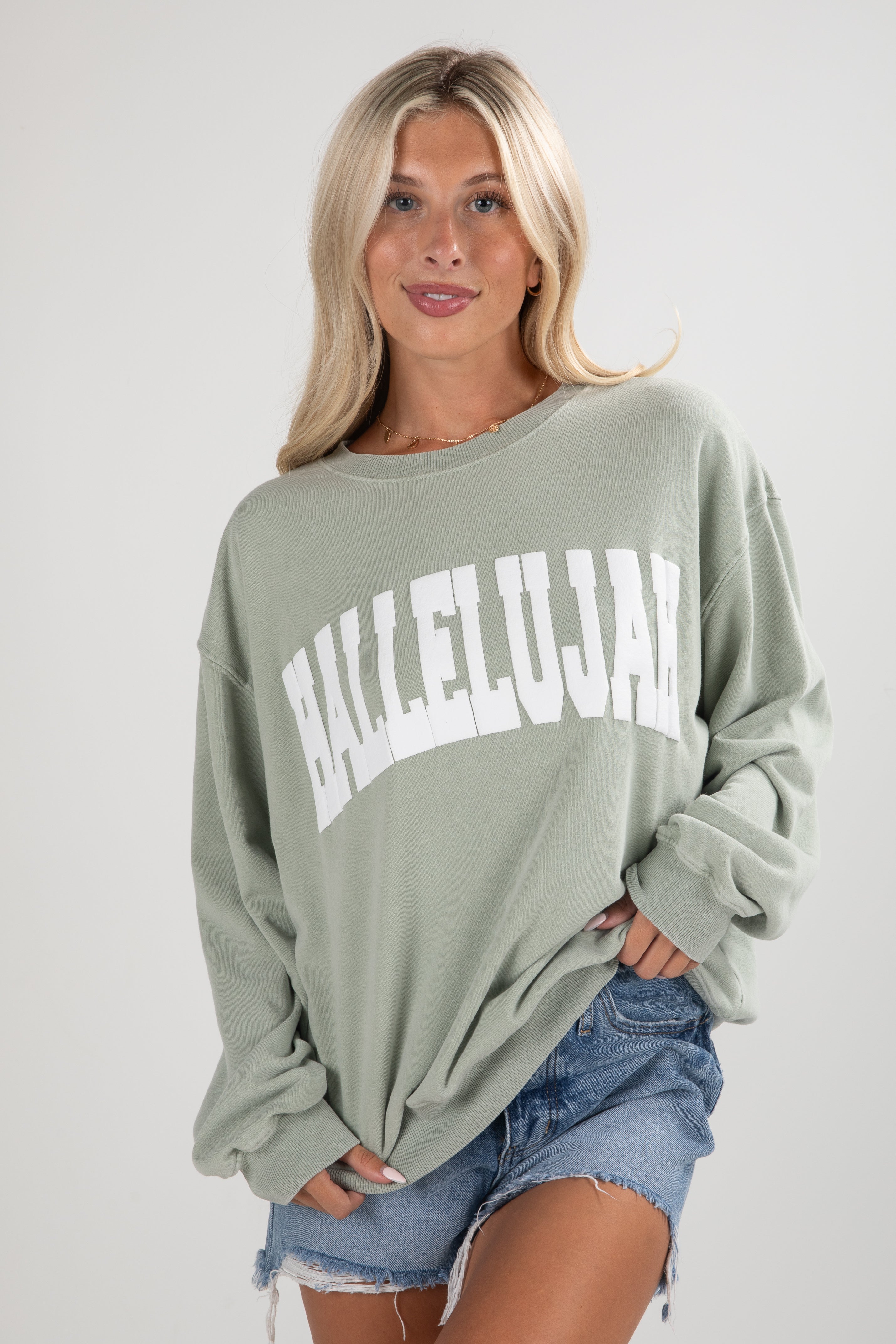 Woman wearing a green sweatshirt with &