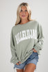 Woman wearing a green sweatshirt with &