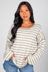 Woman wearing a striped sweater and jeans against a plain background