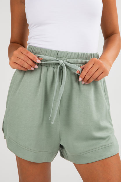 Person wearing green shorts with a white background