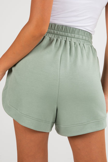 Green shorts worn by a person on a plain background