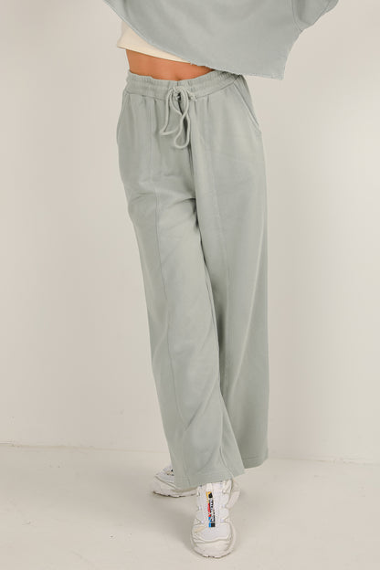 Light gray sweatpants worn by a person on a white background