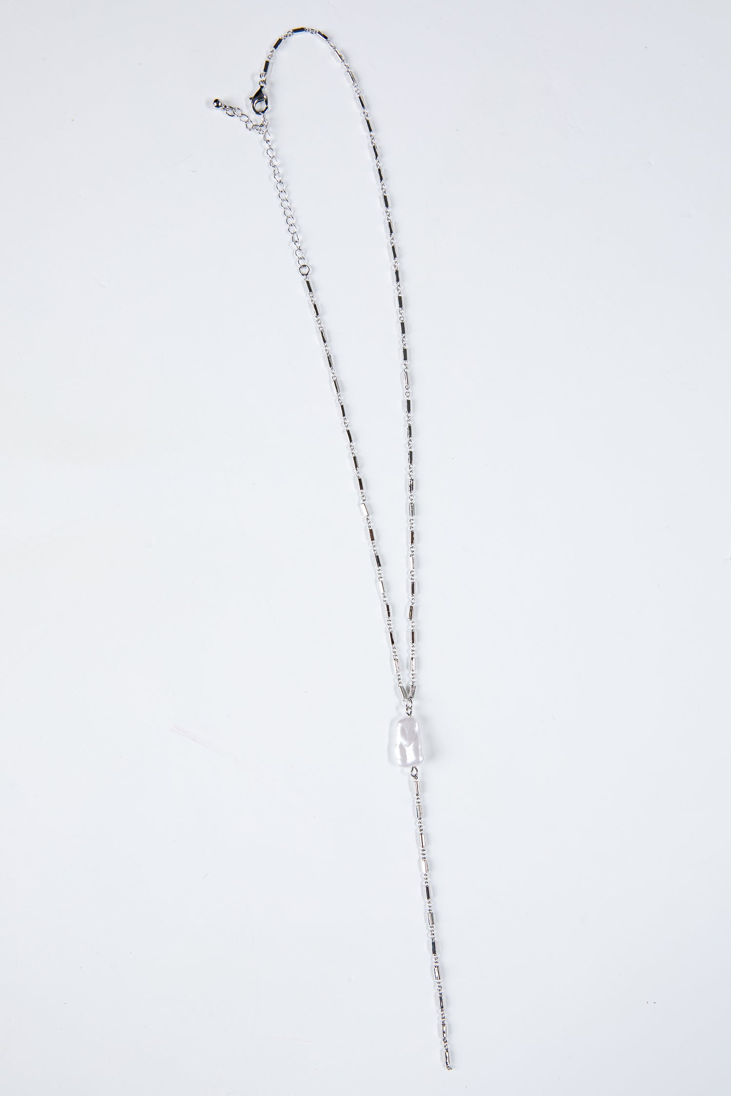 Silver necklace on a light gray background