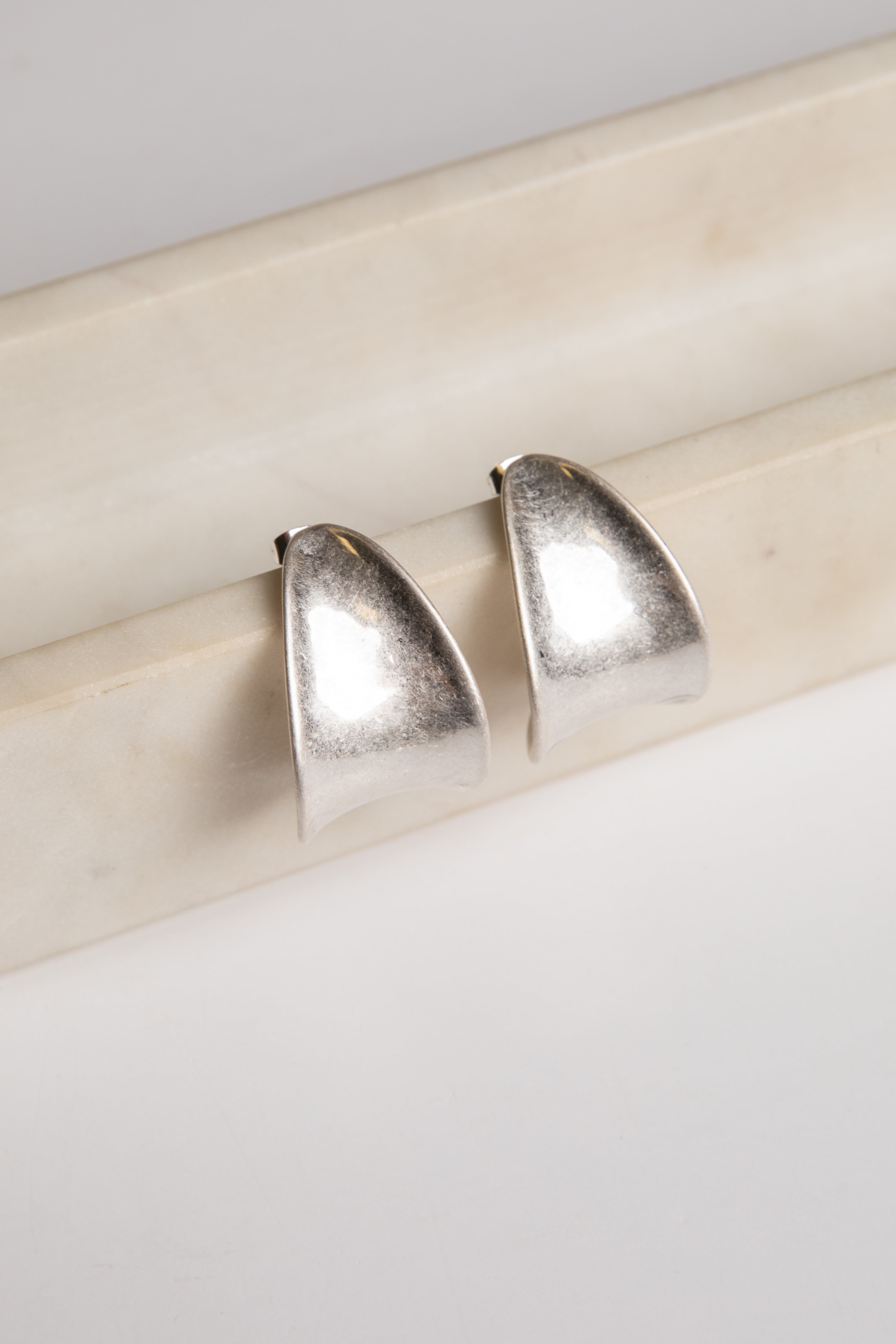 Pair of silver earrings on a light wooden surface