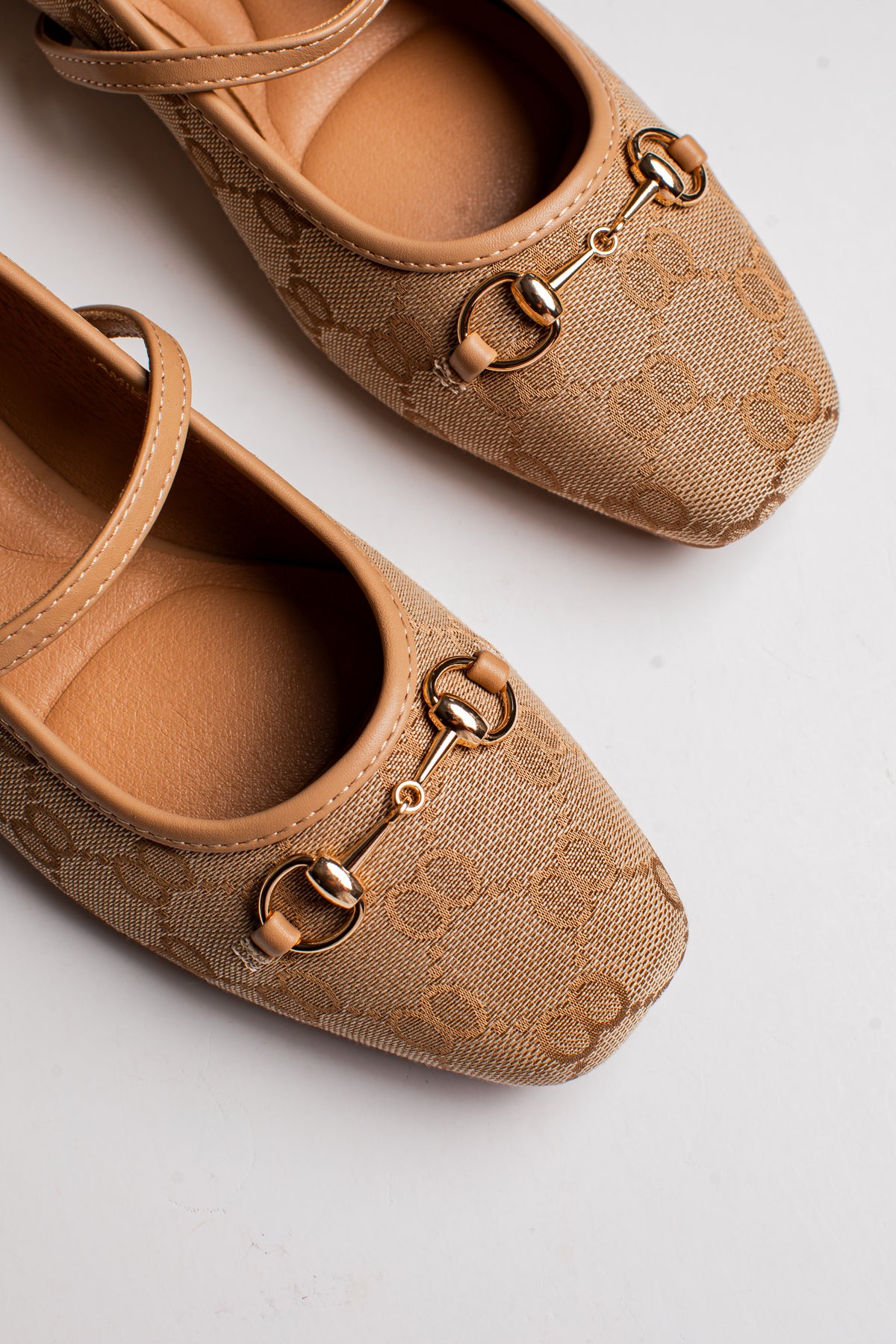 A pair of beige Gucci flats featuring the brand&