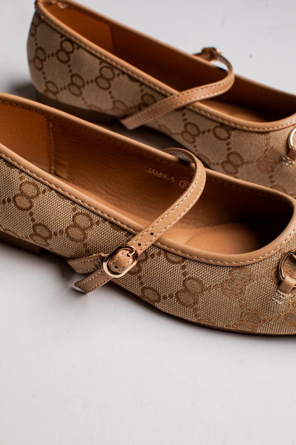 A pair of Gucci flat shoes in the classic GG Supreme canvas, featuring a tan and brown monogram pattern, adjustable strap with gold-tone buckles, and a small gold-tone ring detail on the toe.