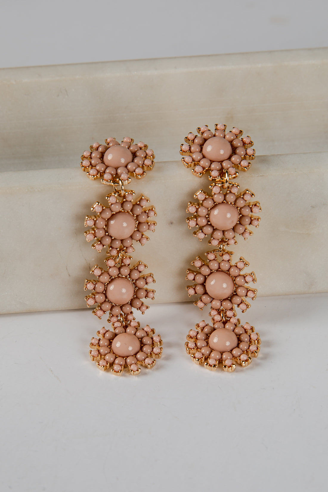 Pair of pink beaded earrings on a light background
