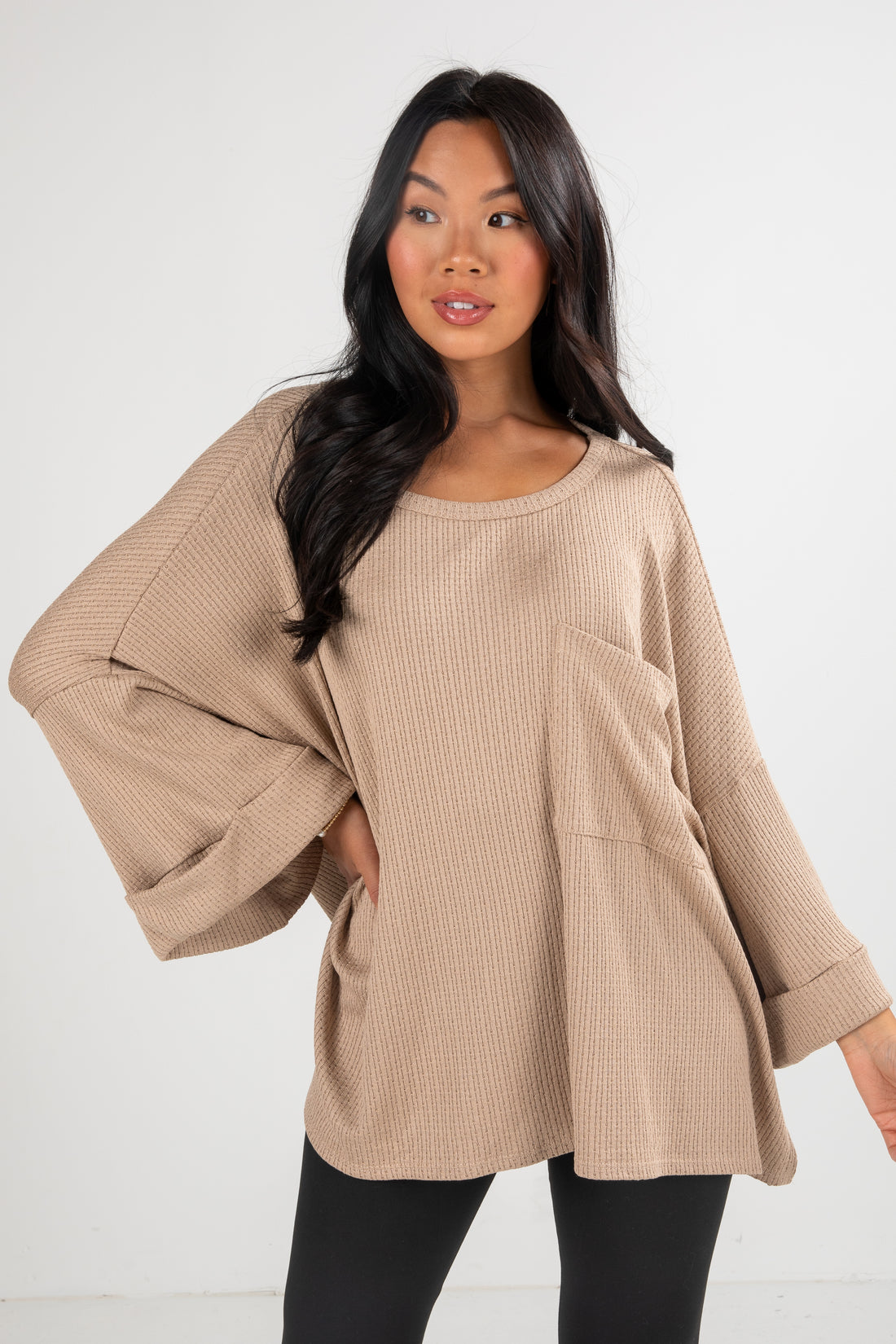 Woman wearing a beige ribbed sweater on a white background