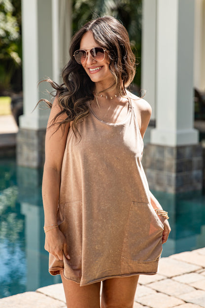 Woman wearing a beige tunic by a pool