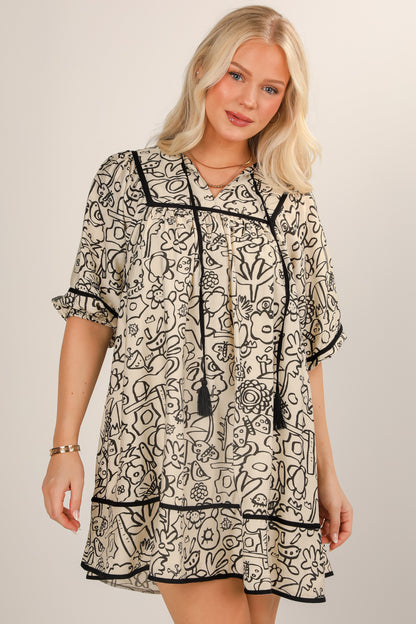 Woman wearing a black and white patterned dress on a plain background