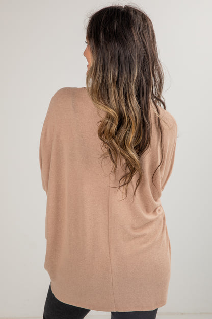 Woman wearing a beige cardigan against a white background