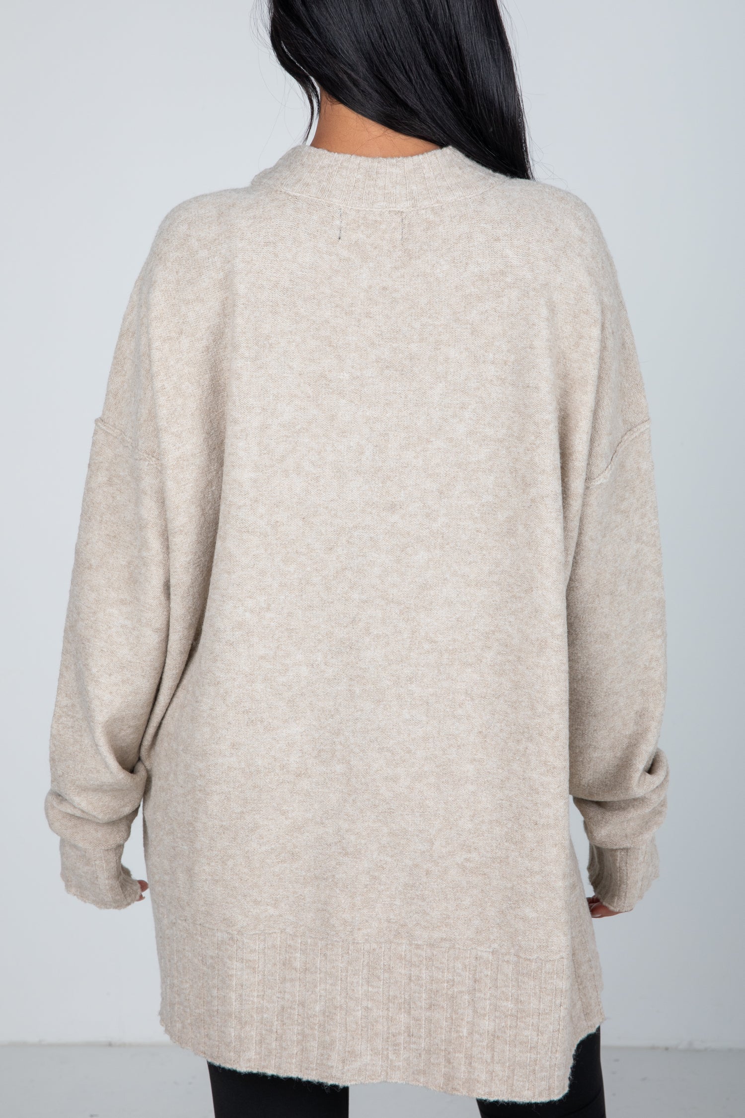 Beige cardigan worn by a person on a plain background
