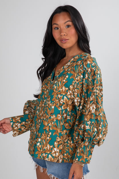 Woman wearing a floral blouse with long sleeves on a white background