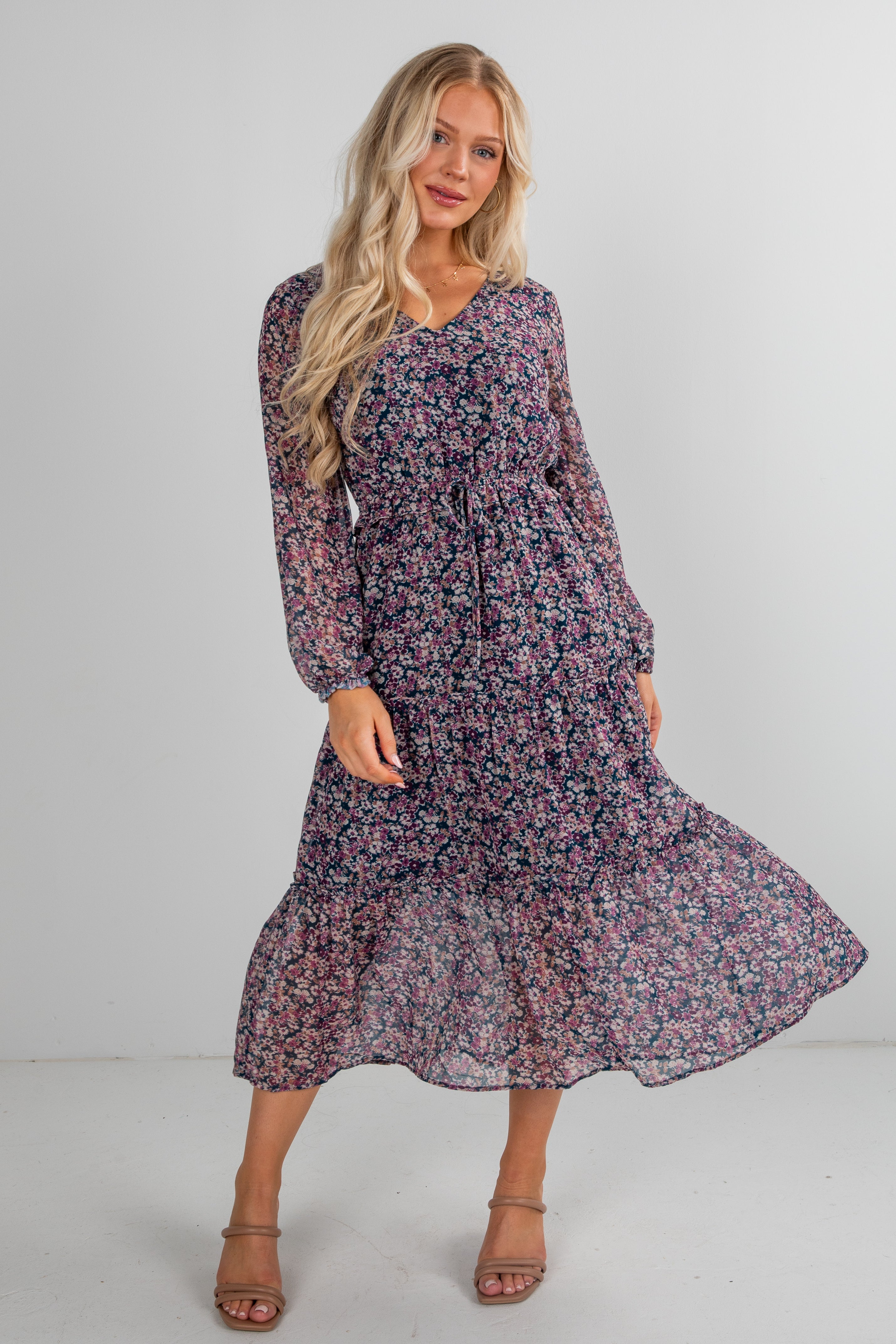 Woman wearing a floral dress against a plain background