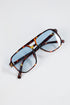 Tortoiseshell sunglasses with blue lenses on a white background
