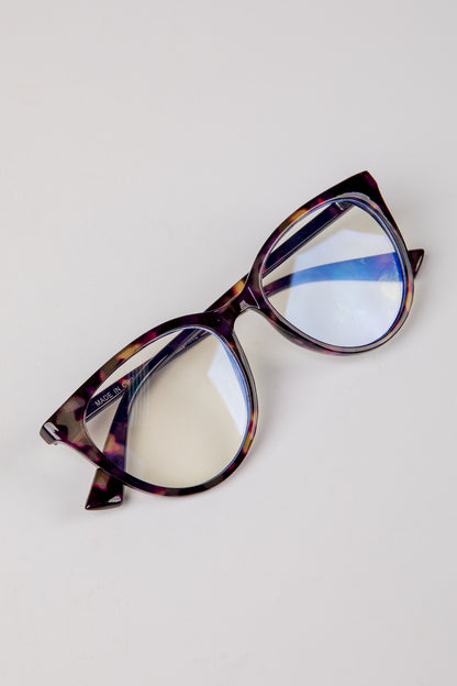 Tortoiseshell cat-eye glasses on a light gray background