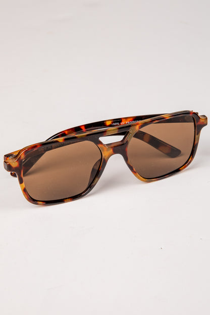 Sunglasses with tortoiseshell frame and brown lenses on a white background