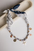 Necklace with charms and bandana-style headband on a white surface