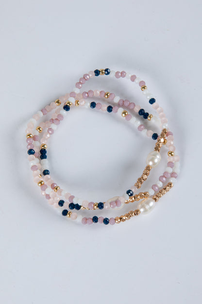 Set of beaded bracelets with pink, blue, and gold beads on a light gray background