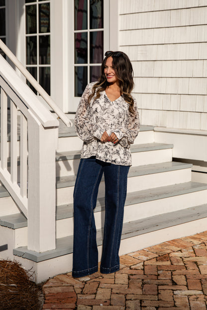 Woman standing on a staircase in front of a white house