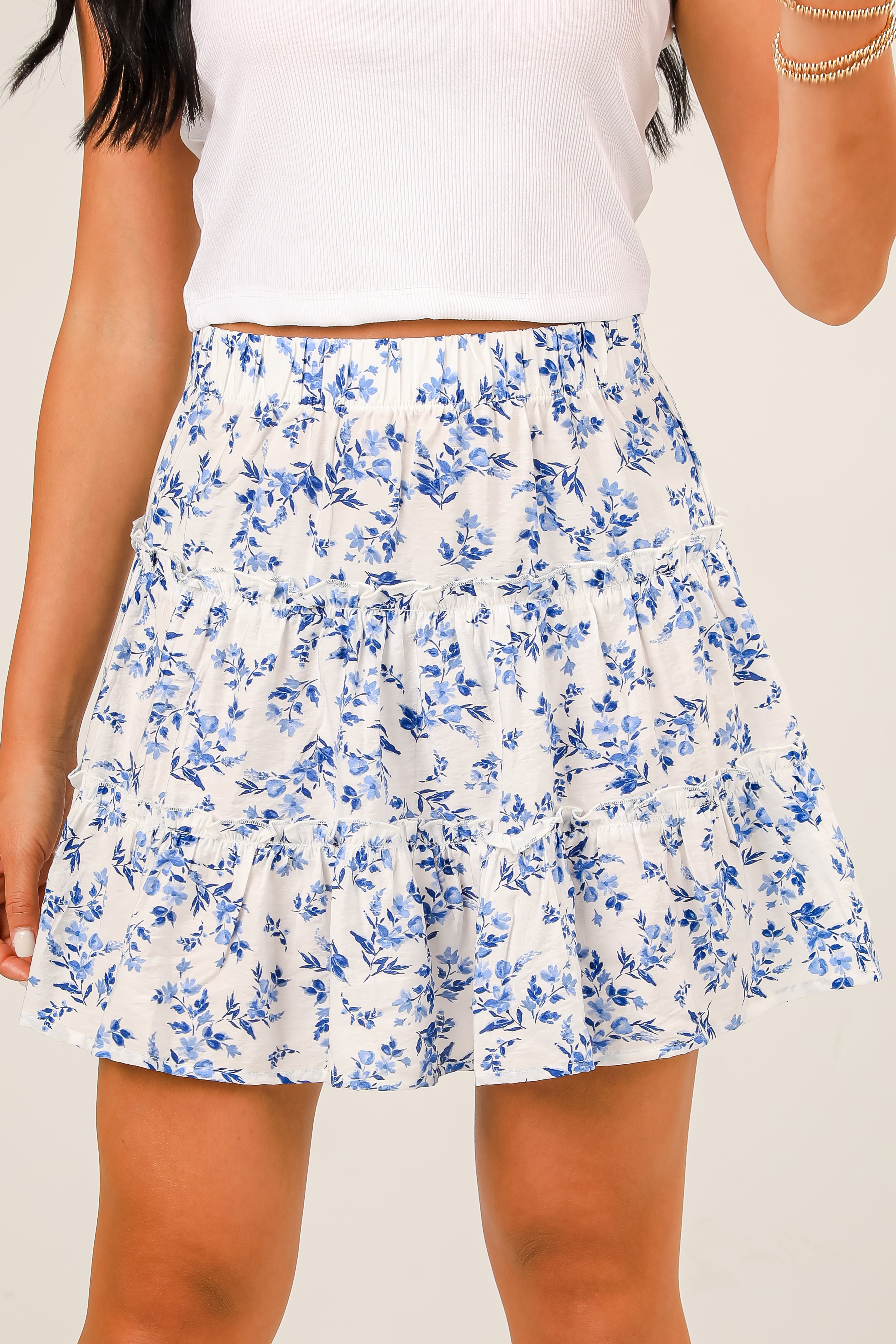 White top with a blue floral skirt on a plain background