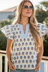 Woman wearing a floral blouse with ruffled sleeves outdoors