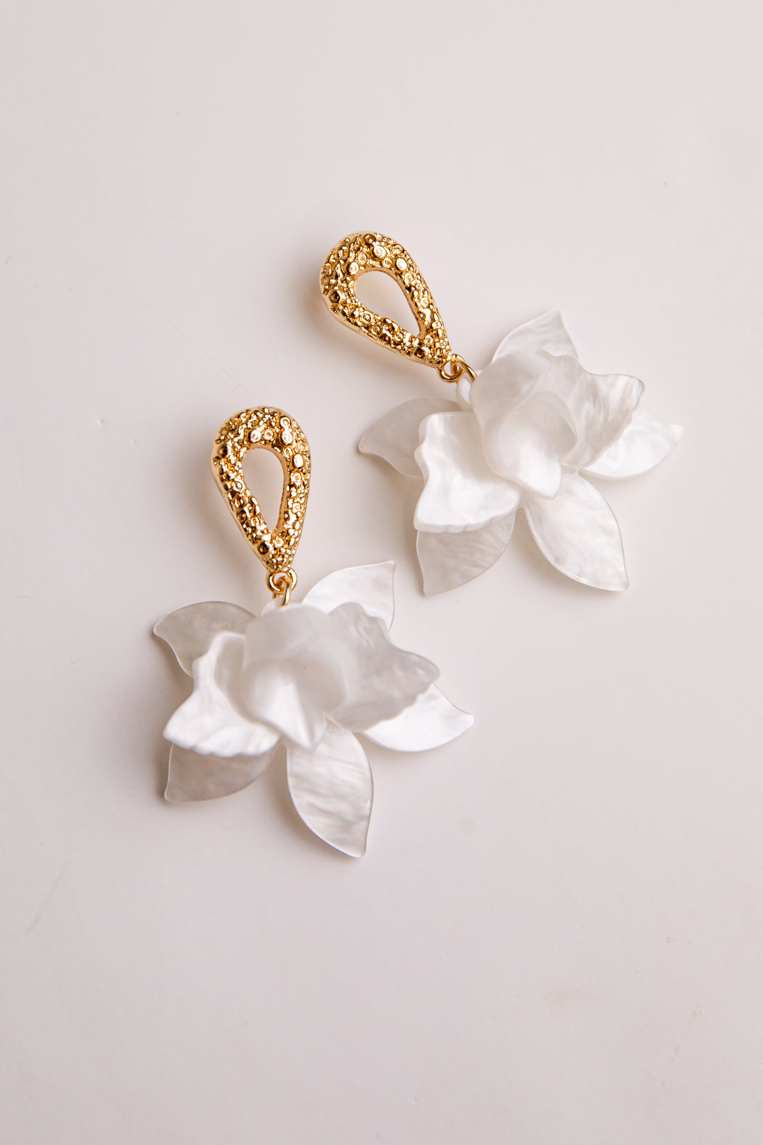 Pair of floral earrings with gold accents on a light background