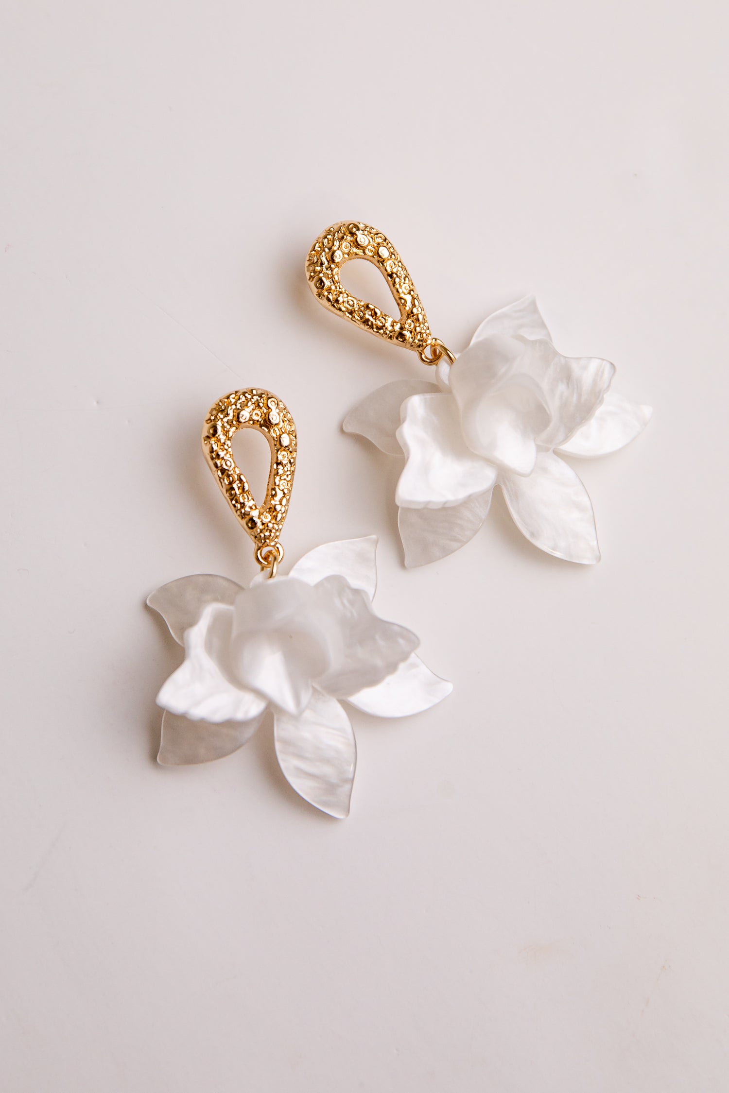 Pair of floral earrings with gold accents on a light background