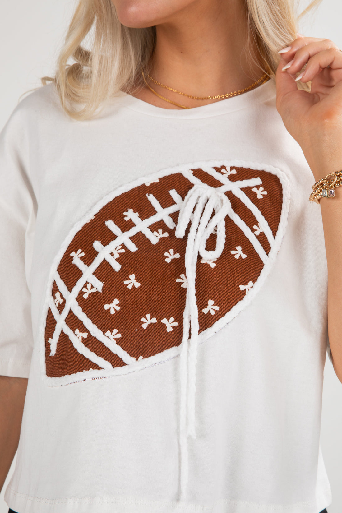 White top with a brown and white patterned design on a plain background
