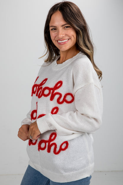 Woman wearing a white sweater with red text on a plain background