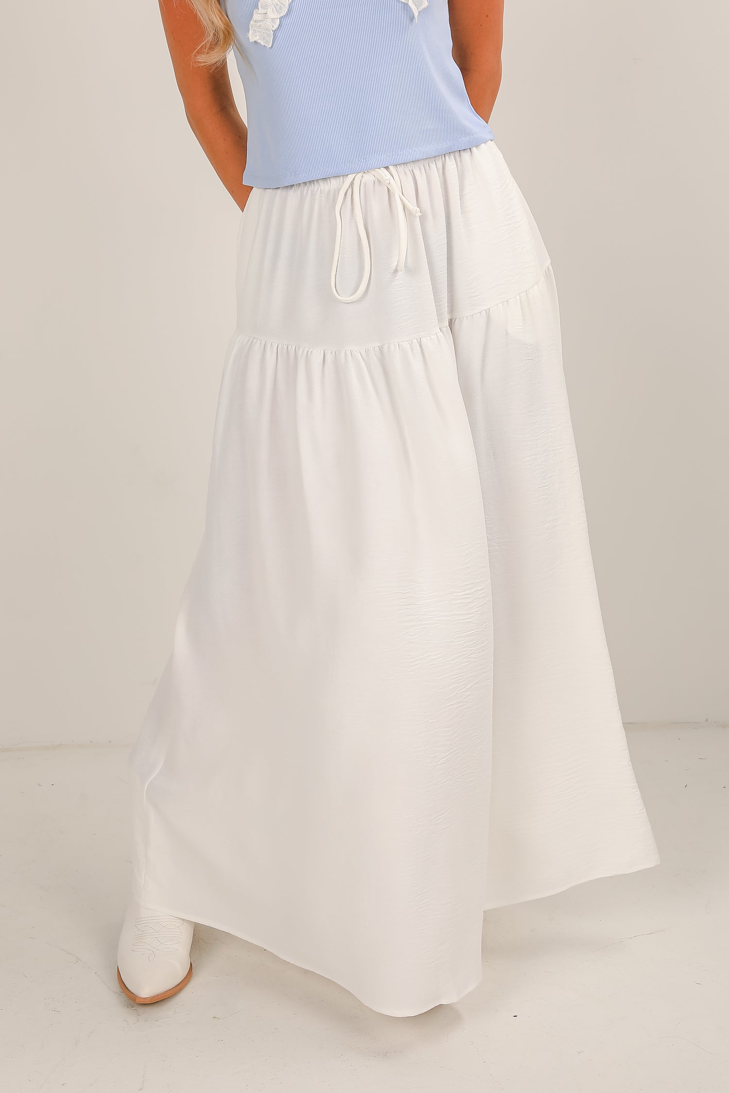 White skirt with a light blue top on a neutral background