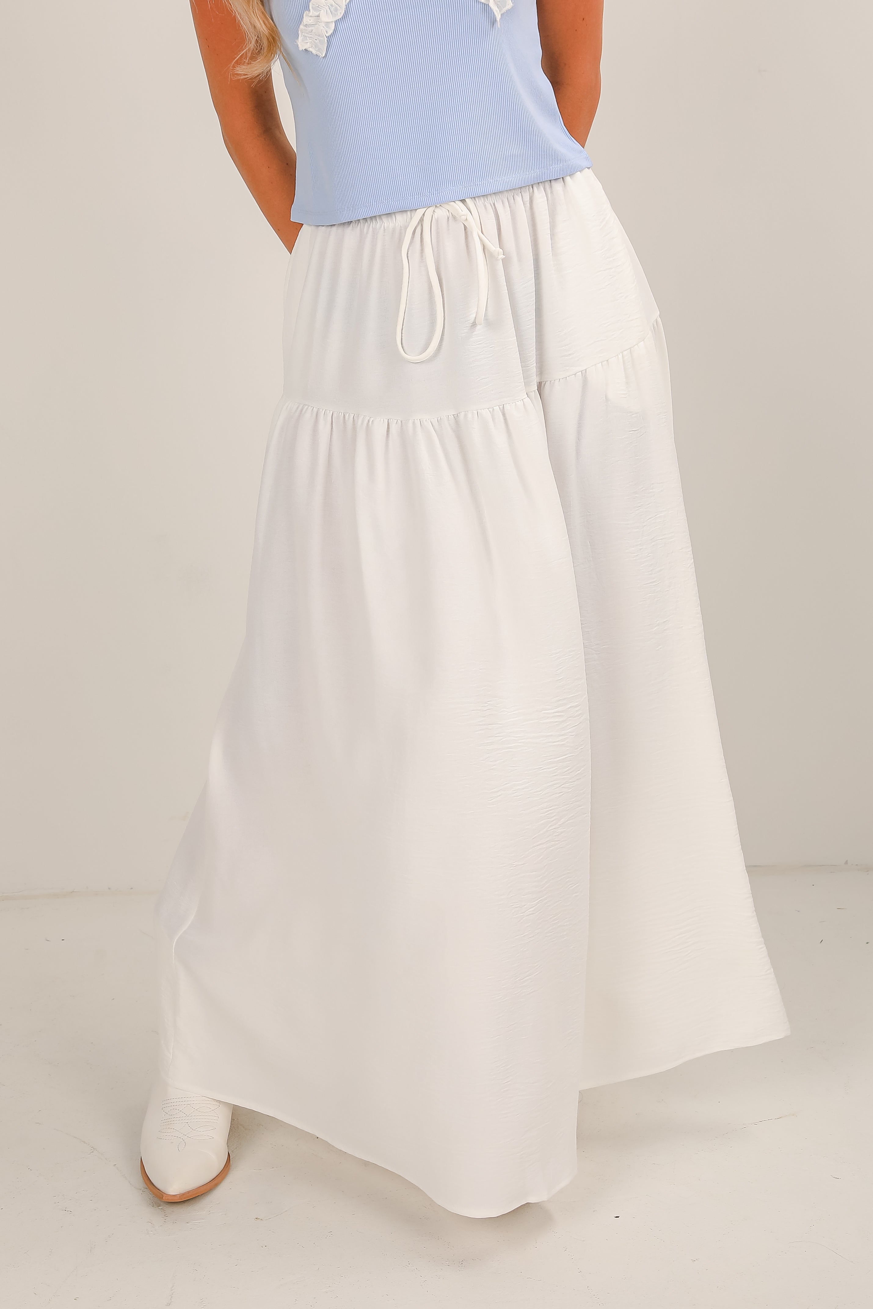 White skirt with a light blue top on a neutral background