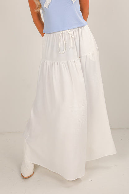 White skirt with a light blue top on a neutral background