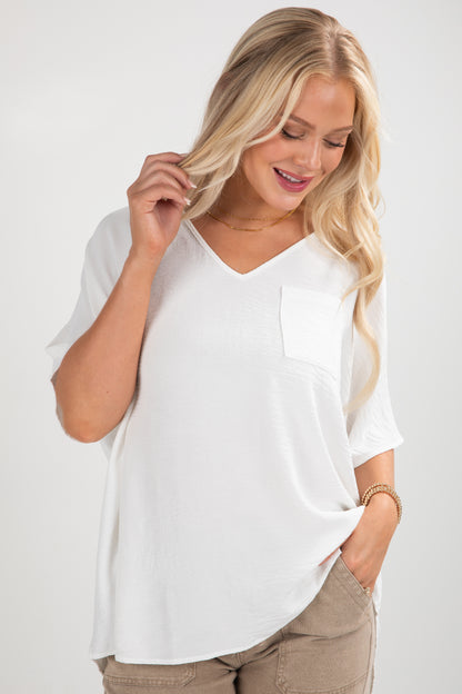 Woman wearing a white oversized shirt and brown pants on a white background