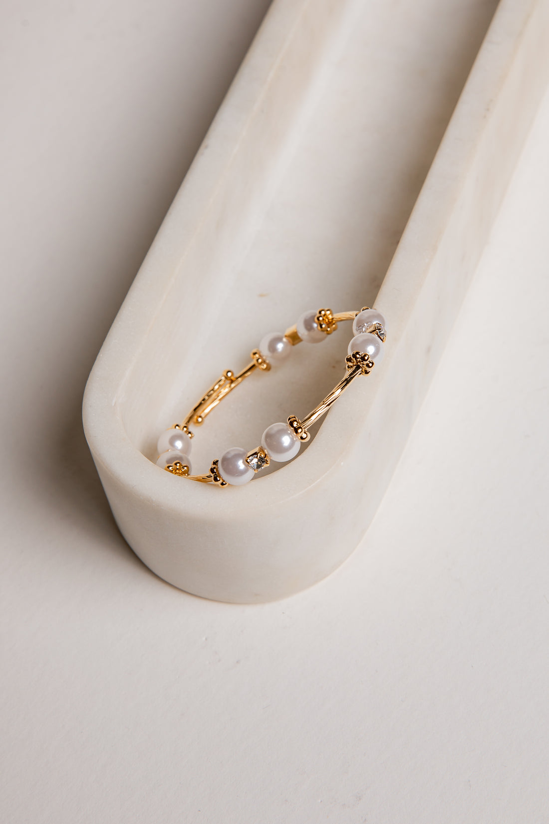 Gold hoop earring with pearls on a white background